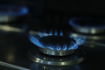 Gas burners with blue flame on stove, closeup