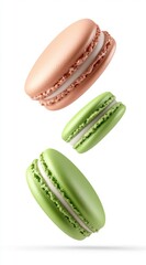 Fototapeta premium Three pastel colored macarons, two green and one pale pink, float against a white background. They are shown in various positions, highlighting the texture and delicate nature of the pastries.