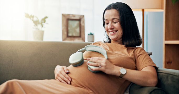 Pregnant woman, belly and headphones on sofa for baby, happy and child development in living room. Mother, person and music for audio stimulation for growth, hearing and relax with streaming in house - Powered by Adobe
