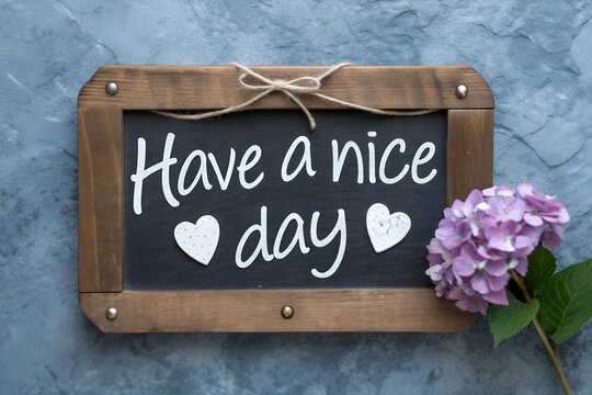 Have a nice day chalkboard with flowers and wooden frame hanging on a wall
