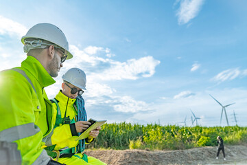 Team of engineers in reflective work suits join hands to inspect and demonstrate their work and...