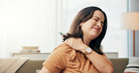 Shoulder pain, discomfort and woman on sofa in home with stress, muscle tension and injury in...