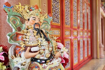 Close up Cai Shen, God Of Wealth Statue in front of Chinese Shrine.