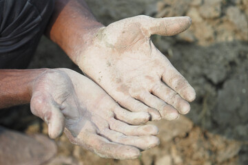Hands covered in mud after working in the field