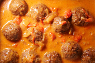 Savory meatballs simmering in a rich tomato sauce in a warm kitchen