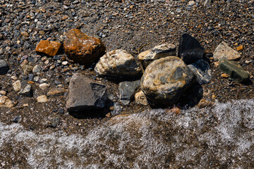 Wet stones on the lake shore beautiful color rocks close up view