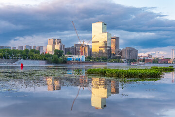 View of Krasnopresnenskaya Embankment in Moscow with reflection in the water. Downtown Moscow, Russia.