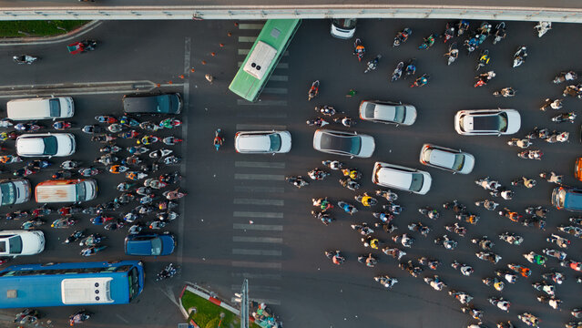 Extreme close up bird Top View of Chaotic Traffic at a Bustling Intersection in Ho Chi Minh City at Sunset - aerial drone