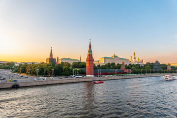 Obraz premium View of Kremlin with Vodovzvodnaya tower, Grand Kremlin Palace from repaired Bolshoy Kamenny Bridge in Moscow city on sunny summer day. Cruise ship sails on the Moscow river
