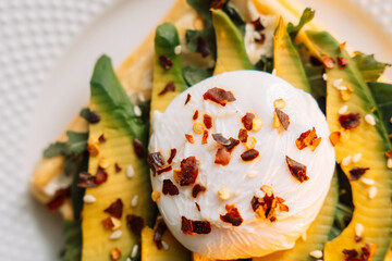 waffles with poached egg avocado on plate on wooden background
