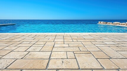 Fototapeta premium Infinity pool merges into the blue ocean under a clear sky, stone tiled deck