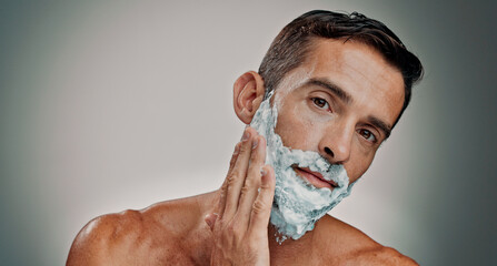 Shaving, cream and cosmetics with portrait of man in studio for beard grooming, beauty and...