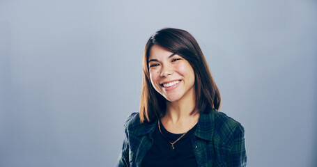 Fototapeta premium Creative, smile and portrait of woman in studio with confidence, mockup space and university. College recruitment, student and happy face with about us, opportunity in education and grey background