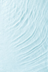 Close up view of sunlit water surface with gentle ripples with light reflections. Crystal clear water with sunlight soft wavy patterns. Abstract nature minimal background, natural textural backdrop