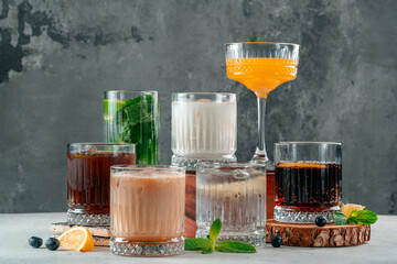 A set of Various alcoholic cocktails with rum and whiskey and Cola on the table decorated with mint and citrus
