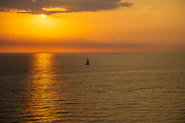 A stunning sunset over the Gulf of Mexico at Clearwater Beach with vast ocean water and boats sailing in Clearwater Florida USA