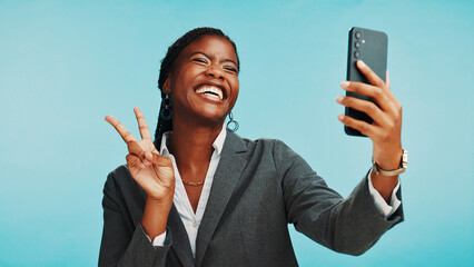 Peace sign, selfie and business with black woman in studio for social media update, brand manager and smile. Company profile picture, happy and photo with person on blue background for website