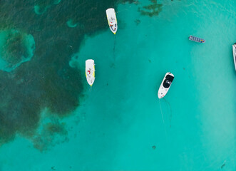 A group of three boats are floating in the ocean