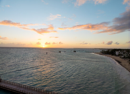 The ocean is calm and the sky is a beautiful orange color