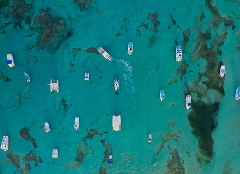 A blue ocean with many boats floating on it