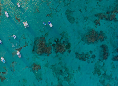 A blue ocean with many boats floating on it
