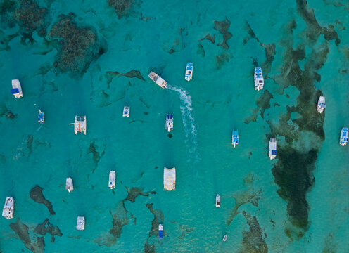 A blue ocean with many boats floating on it