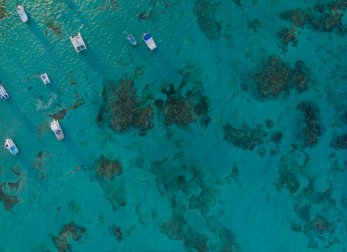A blue ocean with many boats floating on it