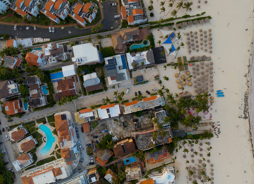 A beach with a lot of houses and umbrellas