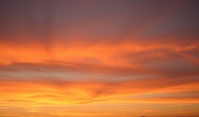Obraz premium Fiery sunset clouds glow warmly across the canvas a breathtaking fiery spectacle. AI Generated