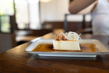 Japanese food is placed on wooden tables inside a restaurant