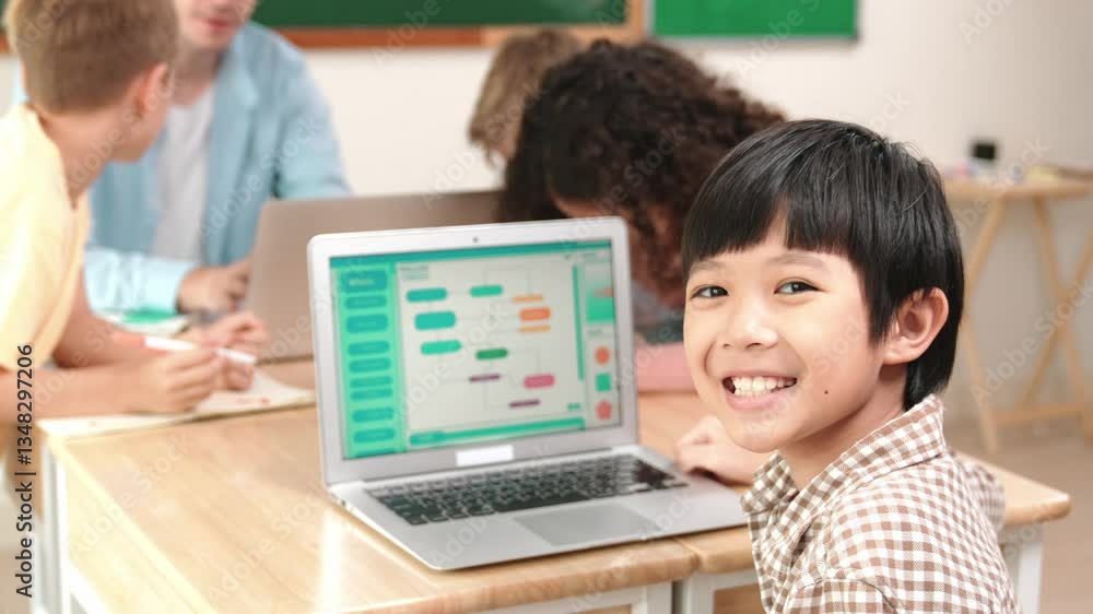 Poster energetic asian boy coding program and looking at camera in stem class while caucasian teacher and d