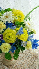 デルフィニウム・ラナンキュラス・カーネーションのナチュラルなアレンジメント背景