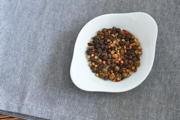 Pepper mix in a white porcelain bowl on the table