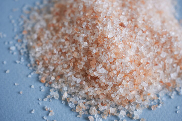 Himalayan pink salt on a blue background close-up.