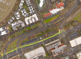 A city street view with a green crosswalk and a red building in the background