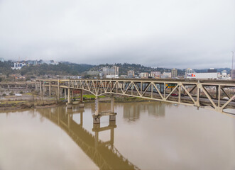 A bridge spans a river with a city in the background