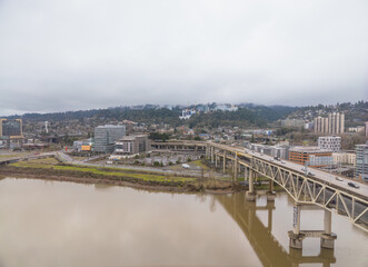 A bridge spans a river with a city in the background