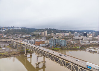 Fototapeta premium A bridge spans a river with a city in the background