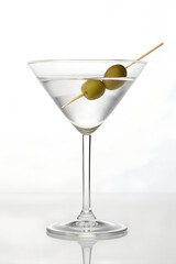 Elegant Martini Glass With Clear Liquid and Olives on a Skewer in a Sophisticated Setting