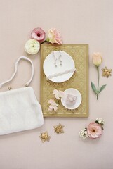 vertical flat lay of bridal details with jewelry and purse
