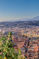 Aerial of Nice, France, with rooftops, a Ferris wheel, and mountains