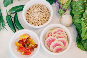 A fresh ingredient spread featuring radishes, cherry tomatoes, p