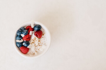 A minimalistic bowl of coconut yogurt topped with berries, cinna