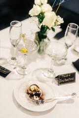Elegant wedding table with white roses, empty cocktails, and an