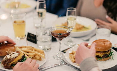 A cozy dinner setting with gourmet burgers, fries, and elegant
