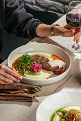 Beef medallions with mashed potatoes and gravy and a glass of wine