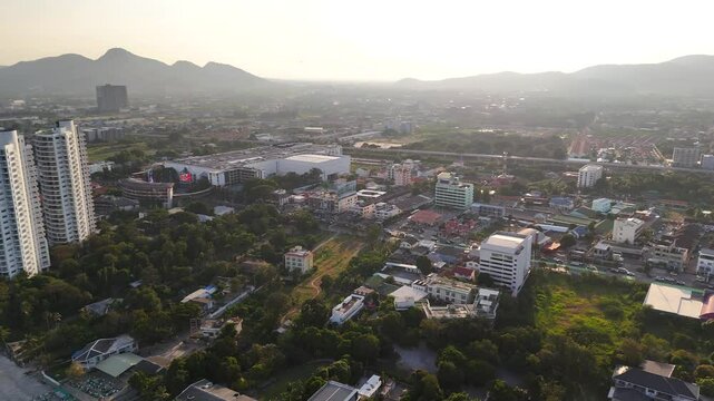 Waves approach long sandy beach of resort city of Hua Hin at sunset