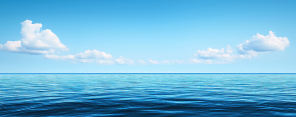 Fototapeta premium A serene ocean view with clear blue water and a bright sky dotted with fluffy clouds, creating a peaceful and tranquil atmosphere.