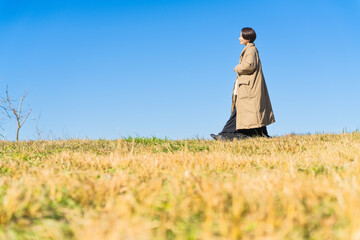 丘を歩く女性　ライフスタイルイメージ