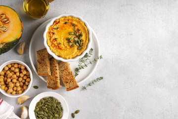 Pumpkin hummus with olive oil and pieces of bread, top view, copy space